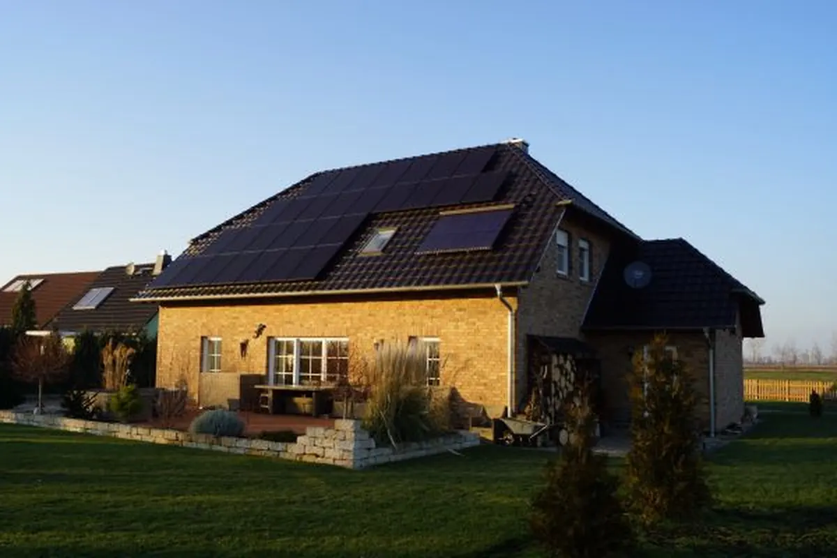 Einfamilienhaus mit gelber Fassade und Photovoltaik